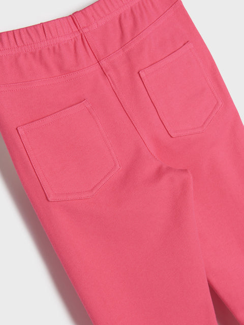 Close-up of pink pants with two front pockets on a light gray background