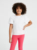 Young girl wearing a white blouse with a collar and pink pants on a white background