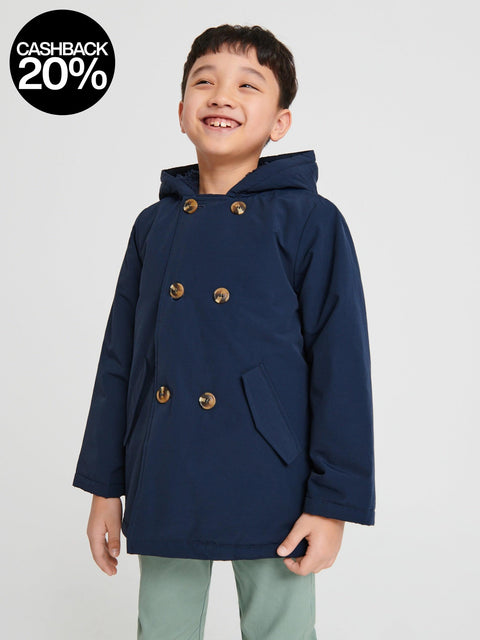 Child wearing a navy blue coat with gold buttons on a light gray background