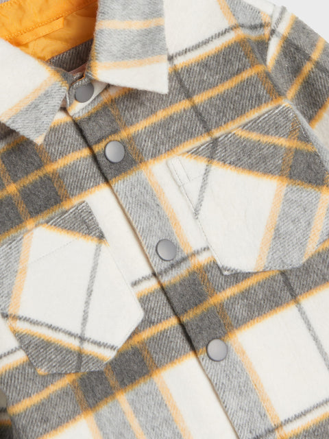 Close-up of a plaid shirt with gray, white, and yellow pattern.