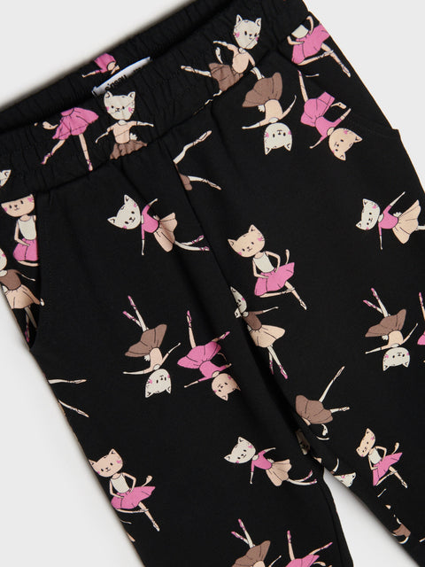 Black pants with a pattern of cartoon characters in pink and brown on a white background