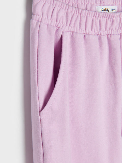 Pink pants with a visible brand label on a light gray background