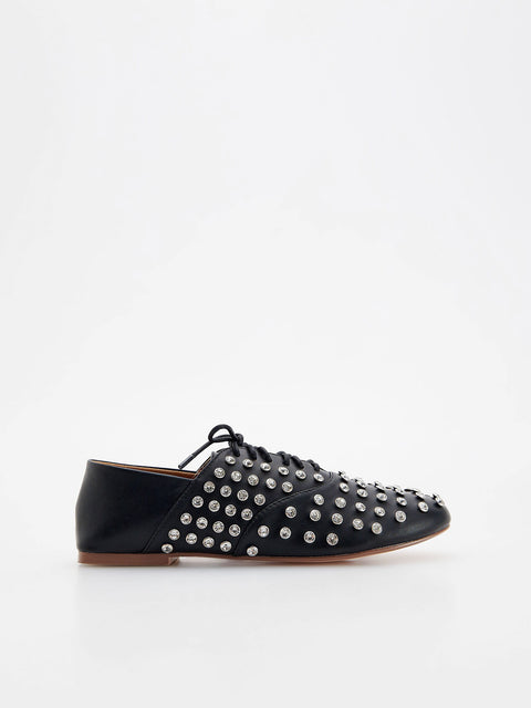 Black studded flat shoe on a white background