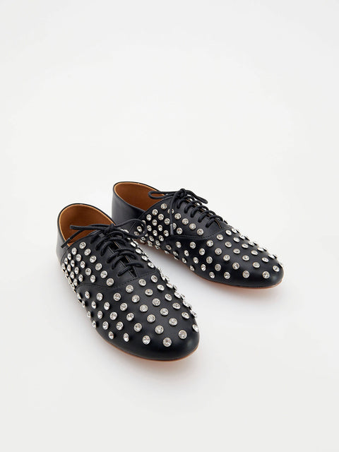 Black leather shoes with silver studs on a white background