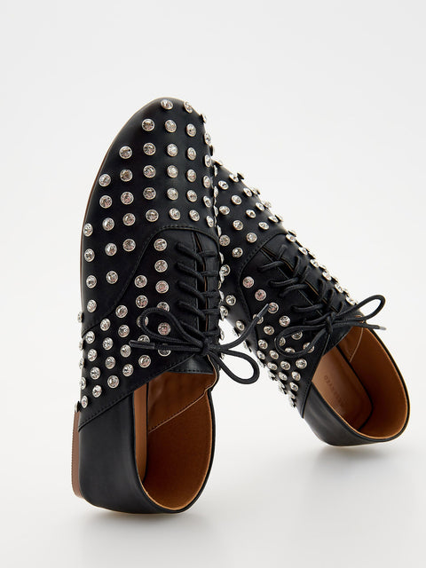 Black lace-up shoes with silver studs on a white background