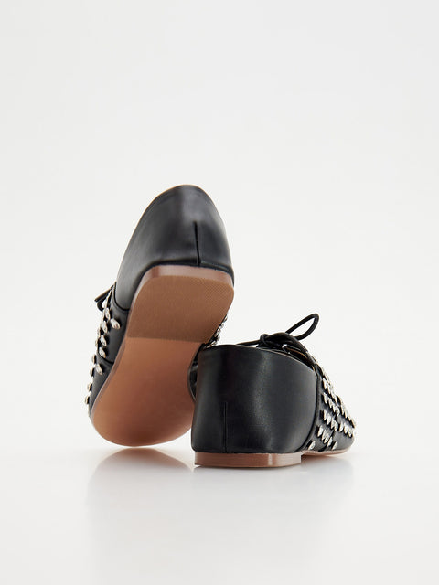 Black leather shoes with brown soles on a white background