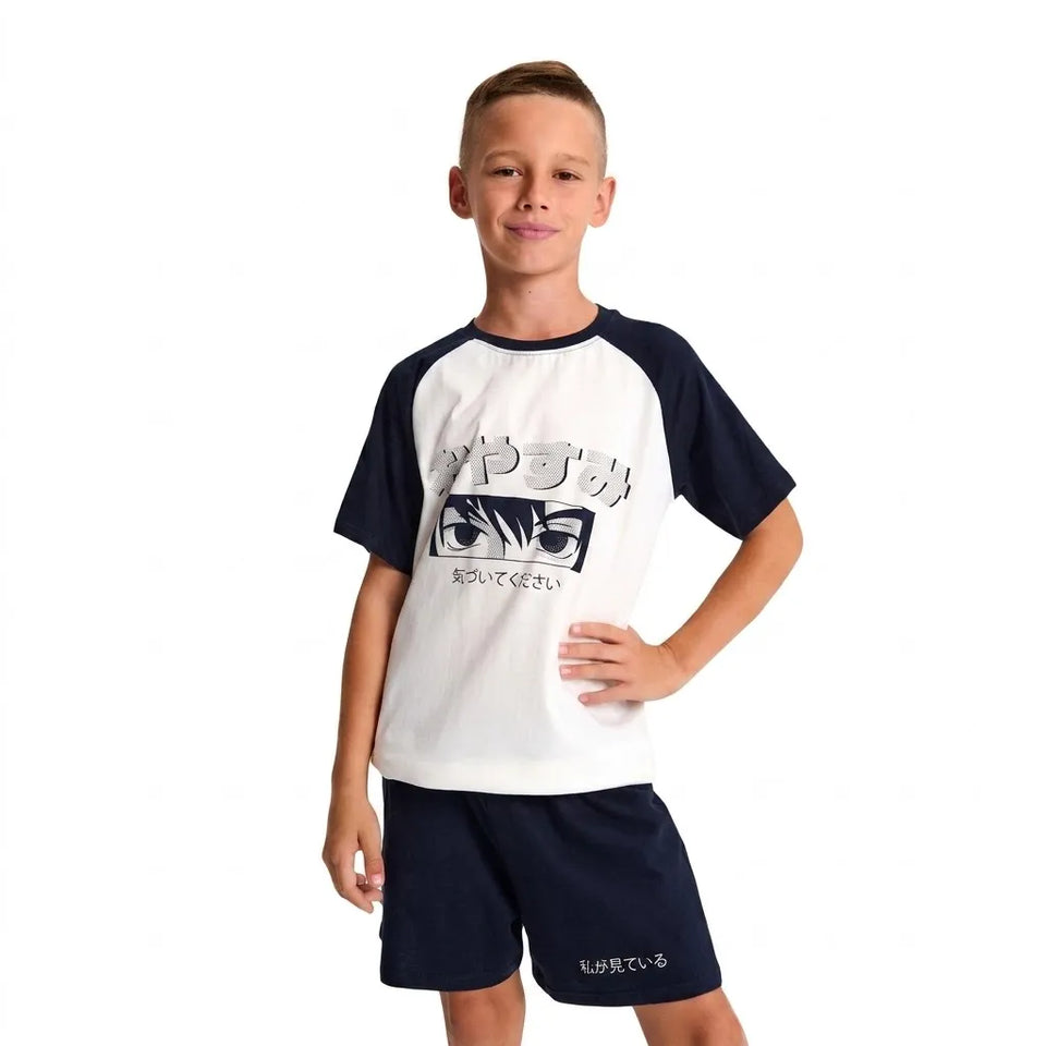 A young boy modeling a two-piece raglan t-shirt and shorts set. The set features a white body with navy blue sleeves and collar, with a graphic print on the front showing the anime character Guts and Japanese text.