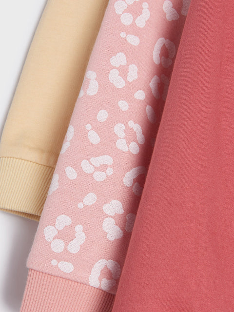 Three fabric swatches in beige, pink with white leopard print, and red.