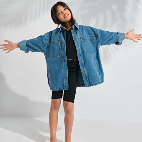Person wearing a blue denim jacket on a white background