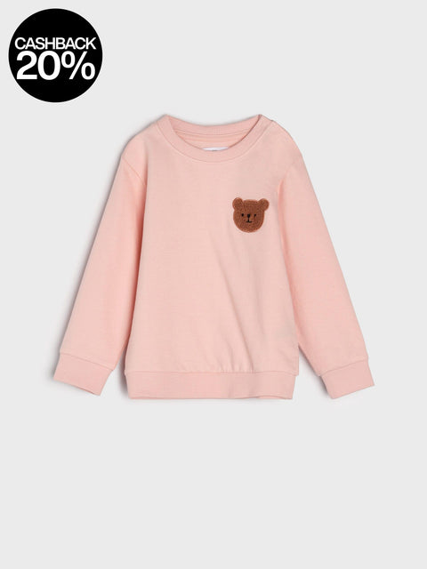 Pink sweatshirt with a bear patch on a light gray background