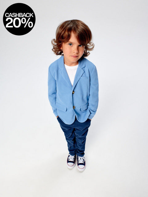 Child wearing a blue blazer and pants with a cashback 20% offer on a white background