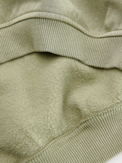 Close-up of a green fleece fabric with stitching details