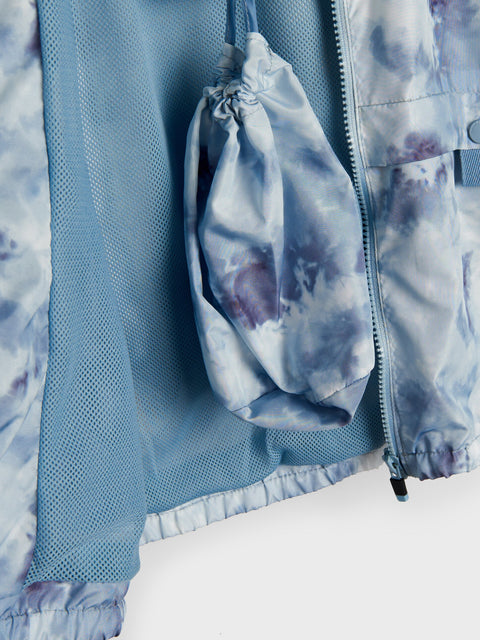 Light blue and purple tie-dye jacket with a drawstring pouch on a matching fabric background.