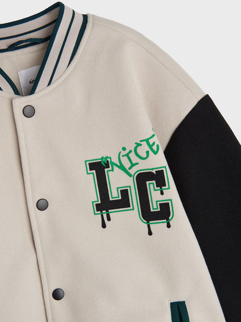 Beige varsity jacket with green and black text on a white background