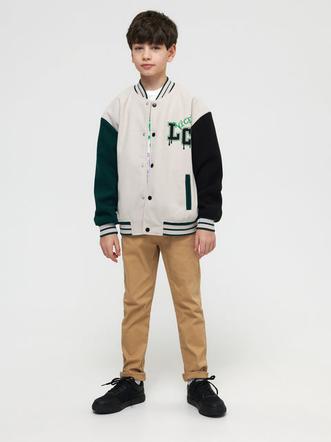 Child wearing a varsity jacket with letterman design on a white background