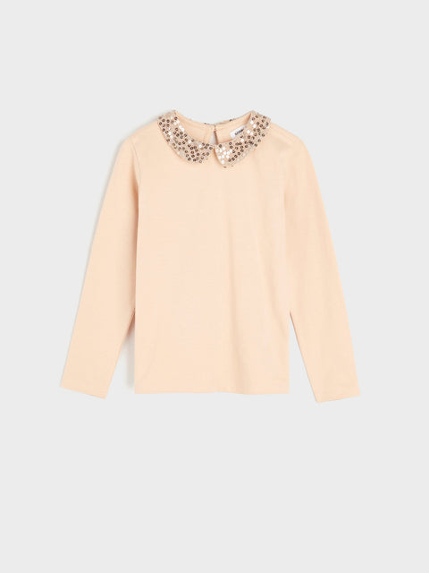 Beige long-sleeve top with decorative collar on a light gray background