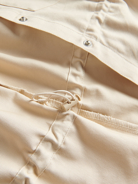 Close-up of beige fabric with a zipper and buttons