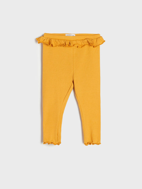 Mustard yellow leggings with ruffled waistband on a white background