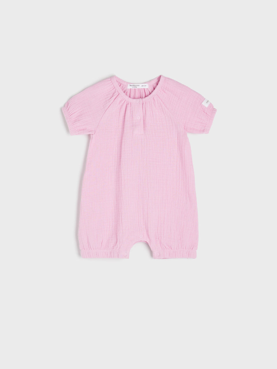 Pink baby romper on a light gray background
