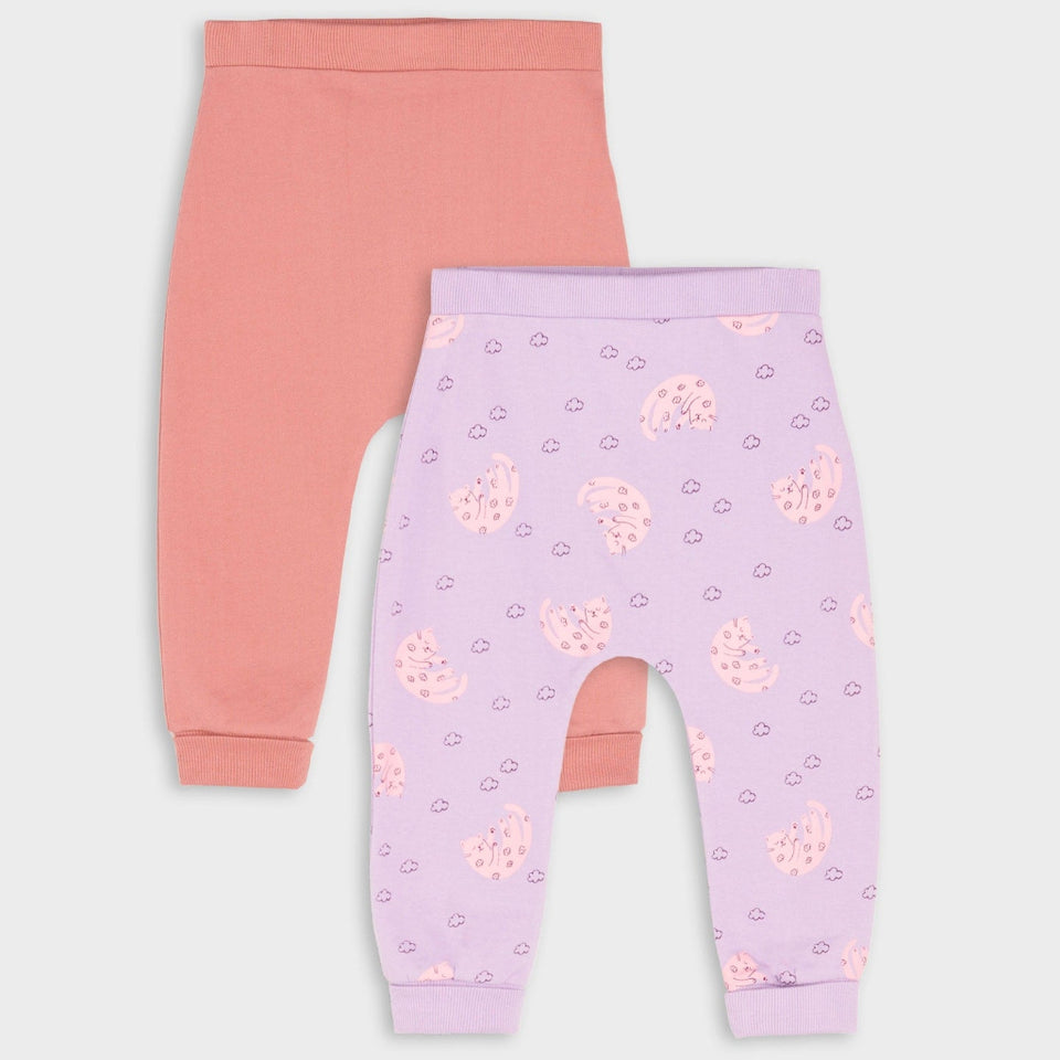 Two pairs of baby leggings laid flat on a light gray background. The back pair is solid coral pink, and the front pair is light lavender with a pink paisley and heart pattern.