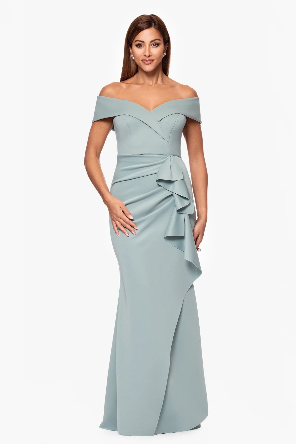 Woman wearing a light blue off-shoulder gown with ruffle details on a white background