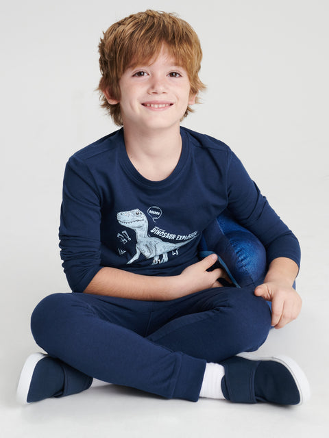 Child wearing a navy blue outfit with a dinosaur design on a white background
