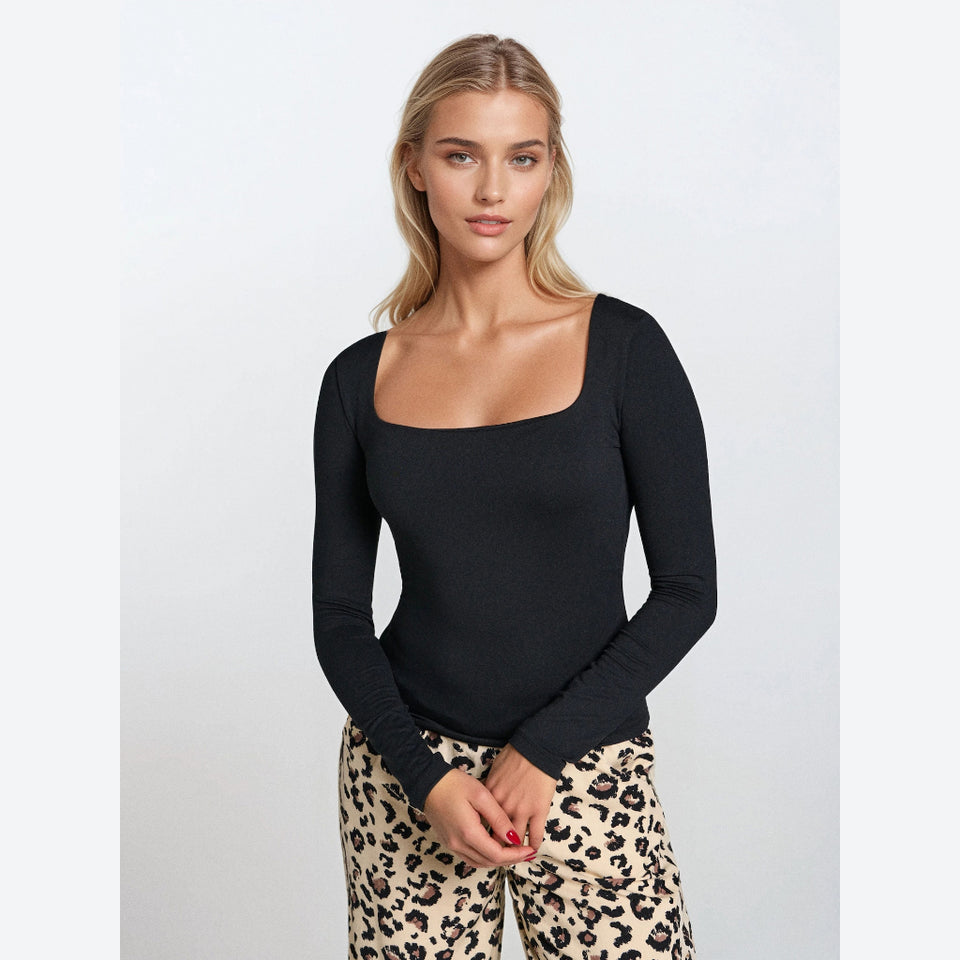 A woman modeling a black long-sleeve top with a wide square neckline, paired with leopard print pants, against a light gray studio background.