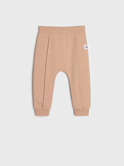 Beige baby pants on a light gray background