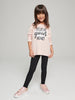 Young girl wearing a pink sweatshirt with 'BELIEVE YOUR HEART' text on a gray background