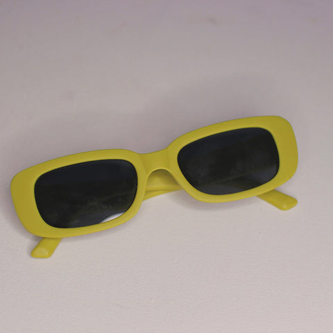Yellow sunglasses with black lenses on a light gray background