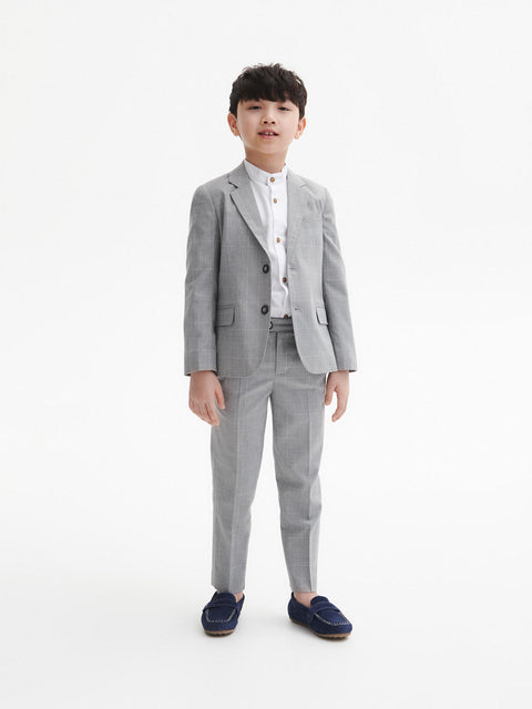 Child wearing a gray checkered suit on a white background