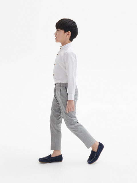 Person wearing a white shirt and gray pants on a white background