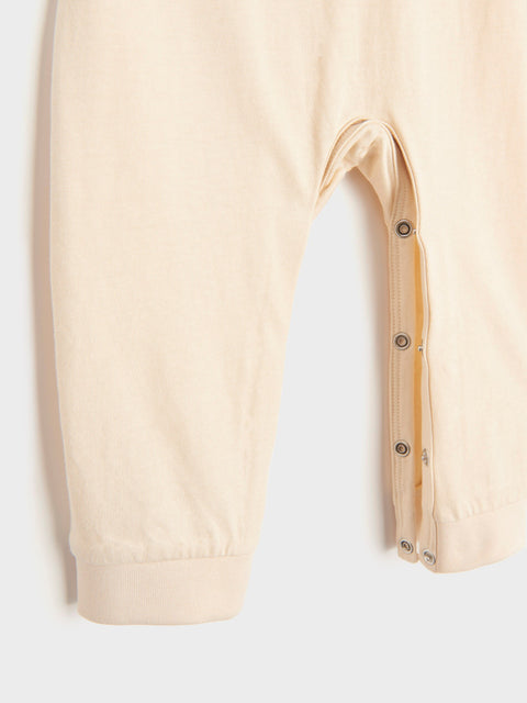 Beige pants with button details on a white background