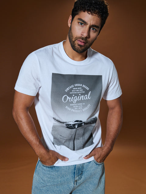 Man wearing a white t-shirt with graphic design on a brown background