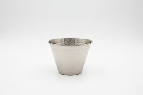 Metal cup leaning against a computer keyboard on a desk