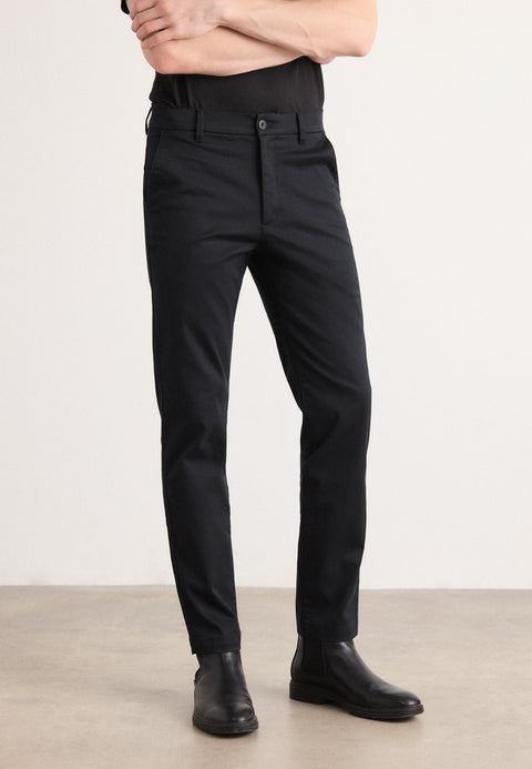 Person wearing black pants and black shoes on a plain background