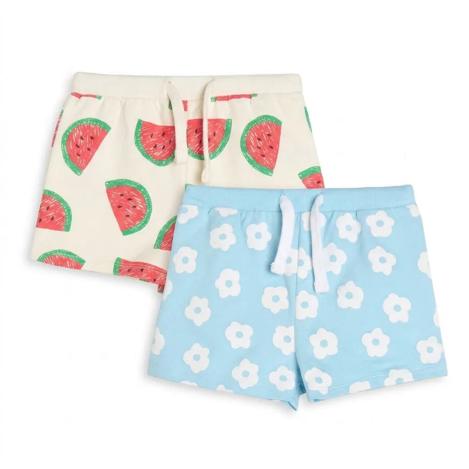 Two pairs of kids' drawstring shorts laid flat on a white background. The top pair is cream with a red watermelon print, and the bottom pair is light blue with a white flower print.