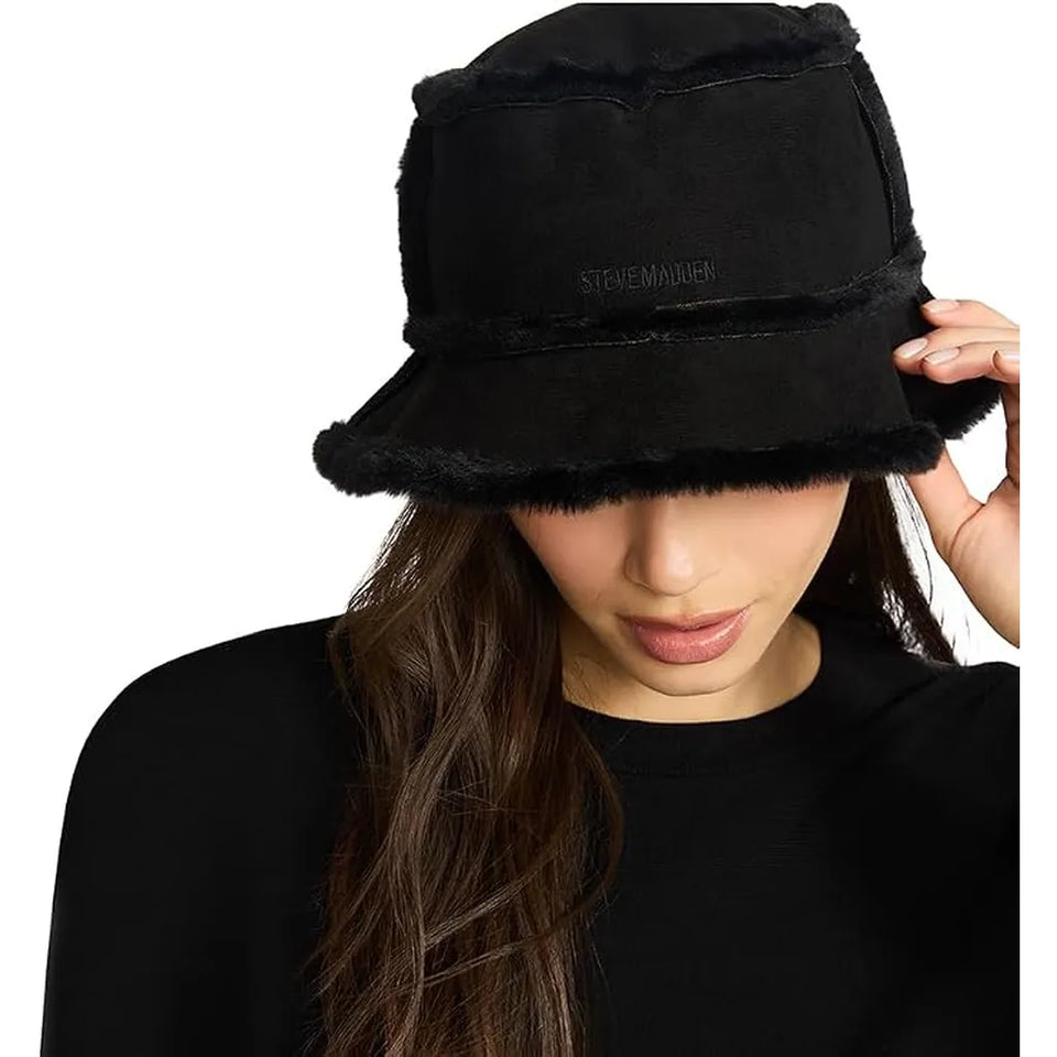 A woman wearing a black bucket hat with fuzzy trim and a small 'STENEMANIER' logo on the front, photographed against a plain white background.