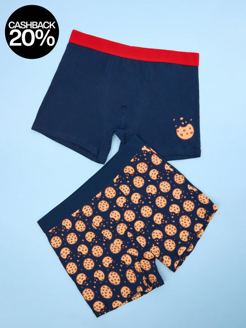 Navy swim shorts with red waistband and cookie pattern on a light blue background