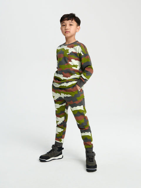 Child wearing a camouflage outfit on a white background
