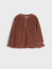 Brown ribbed sweater on a light gray background