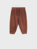 Brown ribbed pants on a light gray background