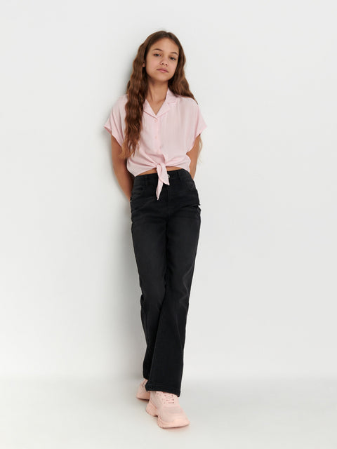 Person wearing a pink shirt and black pants on a white background