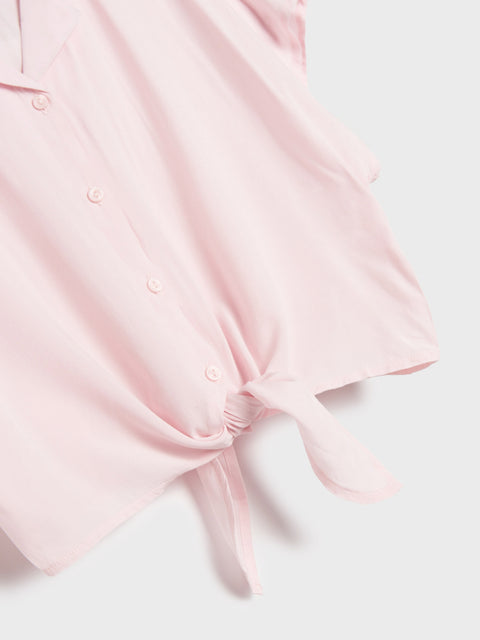 Pink knotted top on a light gray background
