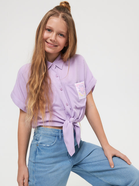 Young girl wearing a purple shirt and blue jeans on a white background