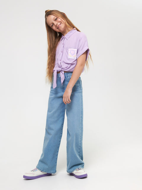 Person wearing a light purple shirt and blue jeans on a white background
