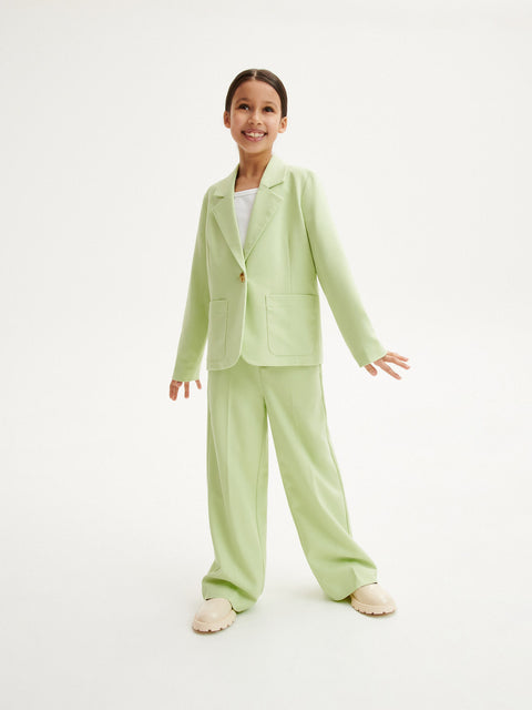 Child wearing a light green suit on a white background