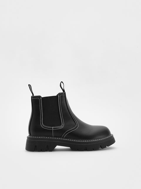 Black Chelsea boot on a light gray background