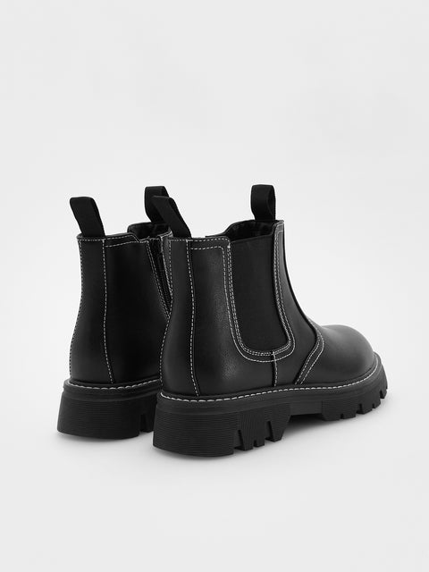 Black Chelsea boots on a white background