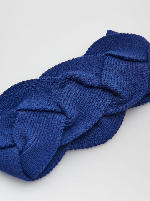 Blue knitted headband on a light gray background